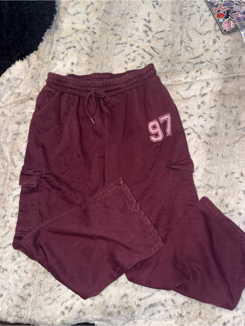 Burgundy cargo style sweats with light pink details and pockets